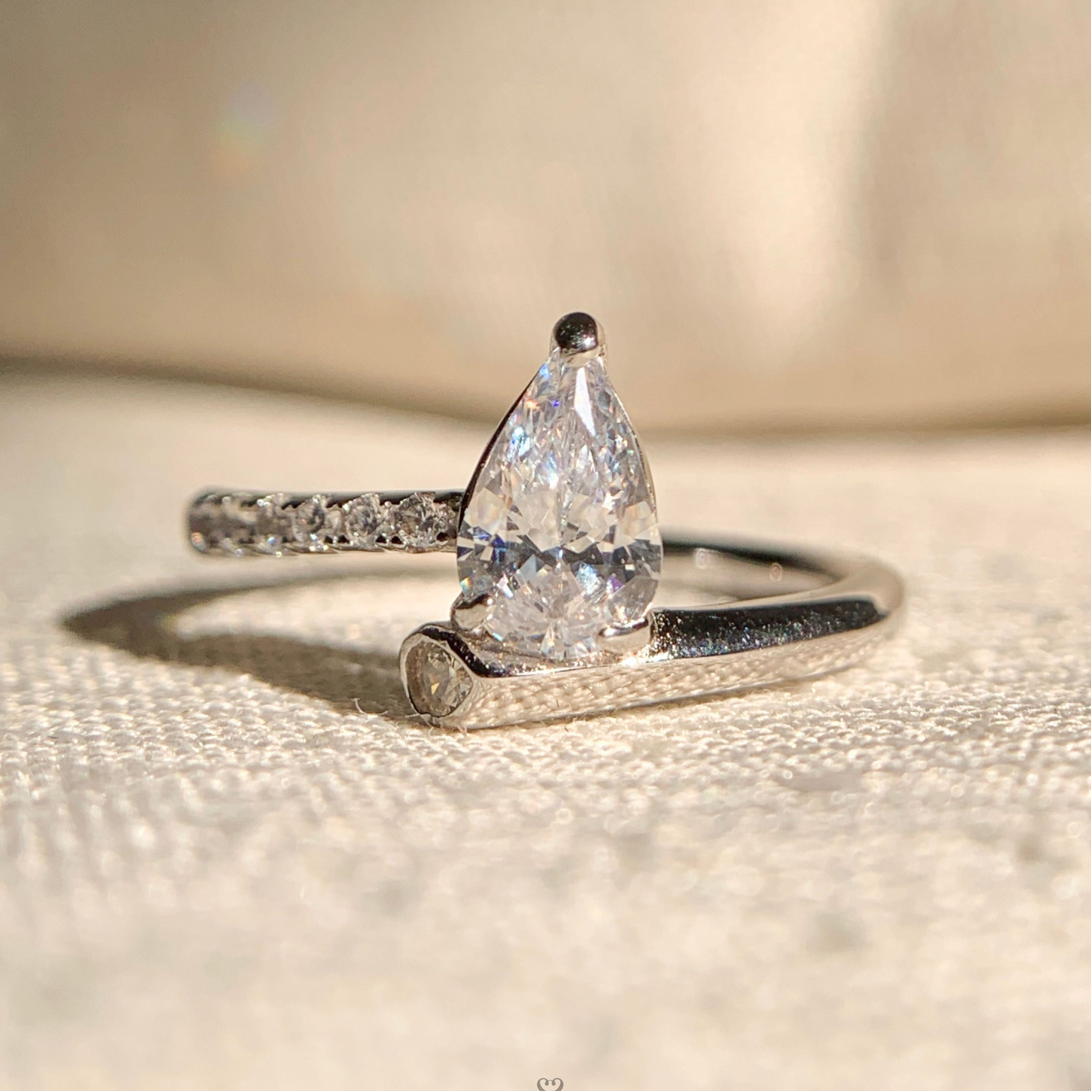 “Elegant pear shaped diamond solitaire engagement ring in polished gold band”